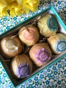 Aprilis Bath Bombs box open to show 6 wrapped bath bombs in different scents, neversaydiebeauty.com