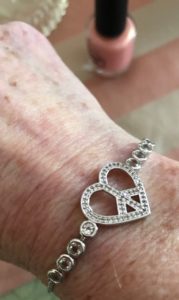 closeup of heart-shaped peace sign in white topaz in silver tone slide bracelet, neversaydiebeauty.com