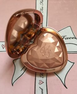 Too Faced Love Light Highlighter open compact, shade Ray of Light rose gold pressed powder embossed with TF initials and prismatic shape, neversaydiebeauty.com