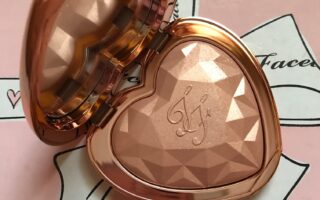 Too Faced Love Light Highlighter open compact, shade Ray of Light rose gold pressed powder embossed with TF initials and prismatic shape, neversaydiebeauty.com