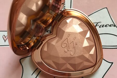 Too Faced Love Light Highlighter open compact, shade Ray of Light rose gold pressed powder embossed with TF initials and prismatic shape, neversaydiebeauty.com