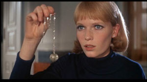 Mia Farrow in Rosemary's Baby holding the tannis root necklace, neversaydiebeauty.com