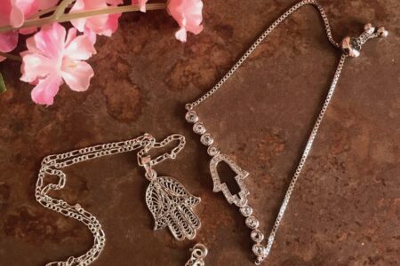 silver necklace and bracelet with the hamsa symbol as centerpiece, neversaydiebeauty.com