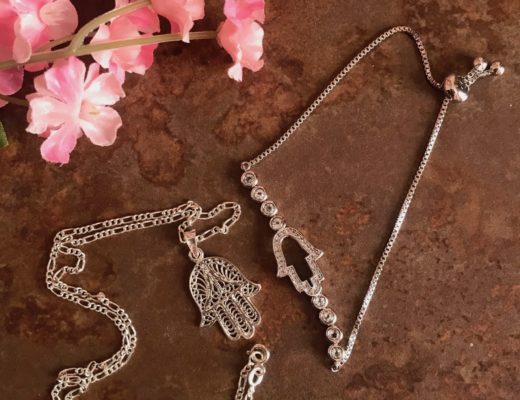 silver necklace and bracelet with the hamsa symbol as centerpiece, neversaydiebeauty.com