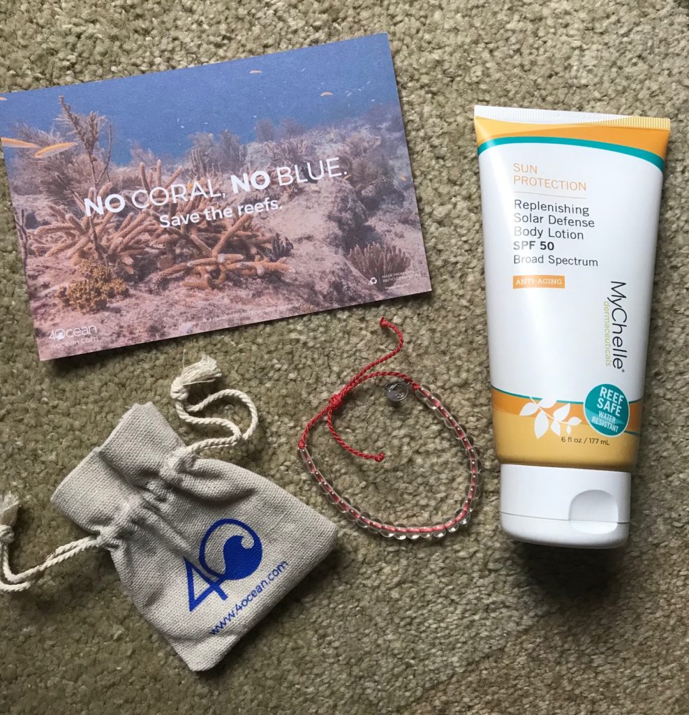 MyChelle Replenishing Solar Defense Body Lotion SPF 50 with bracelet, bag and postcard supporting the Coral Reef Foundation