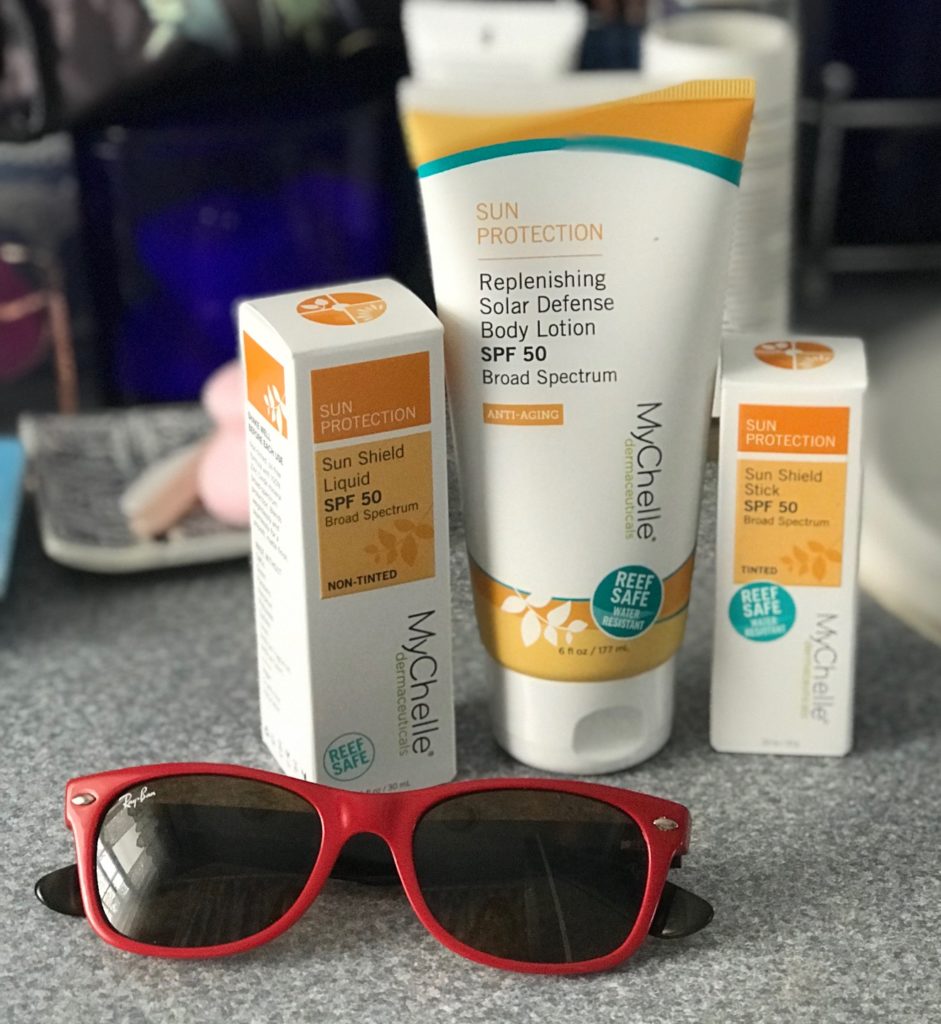 three new zinc oxide sunscreens from MyChelle in their outer packaging: Sun Shield Liquid and Stick and Replenishing Solar Defense Body Lotion, all with SPF 50