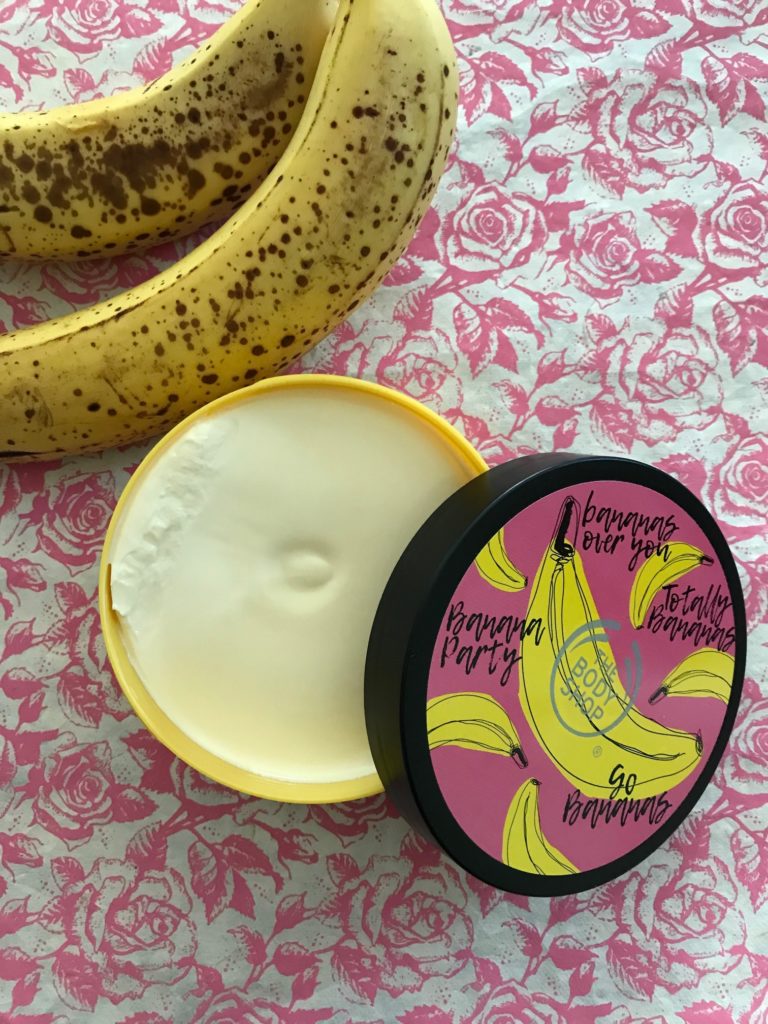open jar of The Body Shop's Banana Body Butter with ripe bananas, neversaydiebeauty.com