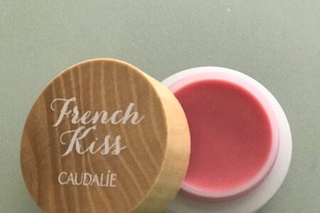 open pot of Caudalie French Kiss Tinted Lip Balm in natural pink shade, Innocence, neversaydiebeauty.com