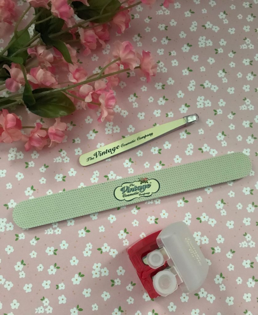 The Vintage Cosmetics Company tweezer, emery board and sharpener showing their logo on the products, neversaydiebeauty.com