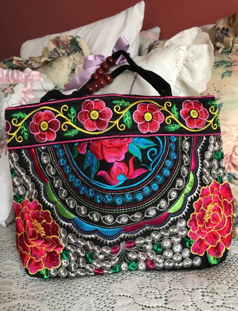 closeup of brightly colored embroidered purse bought on Open Sky, neversaydiebeauty.com