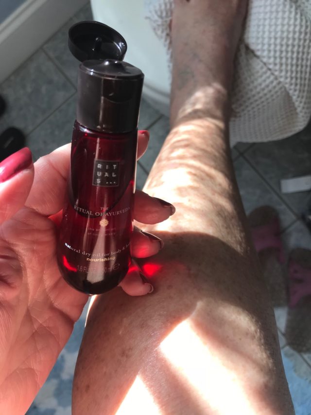 me putting Rituals Ayurveda Dry Body Oil on my leg after a shower, neversaydiebeauty.com