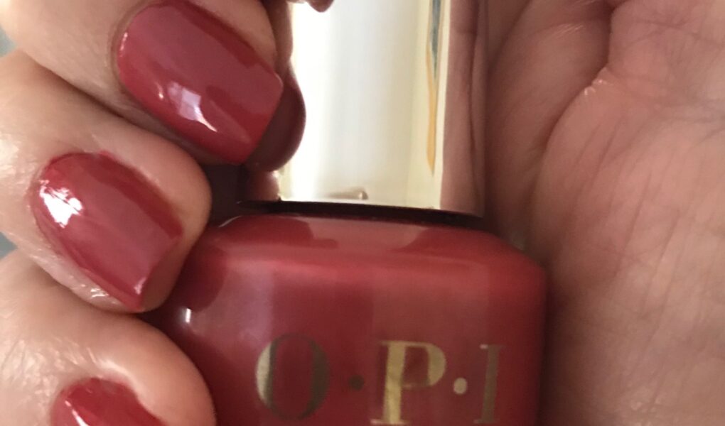 my nails wearing OPI Infinite Shine 2 Grand Canyon Sunset holding the bottle, neversaydiebeauty.com