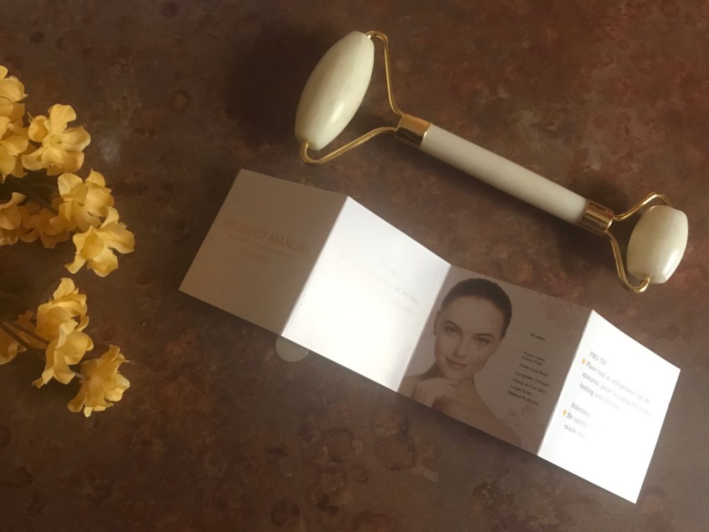 Facial roller massage tool made from white jade with product manual from Skin And Senses, neversaydiebeauty.com