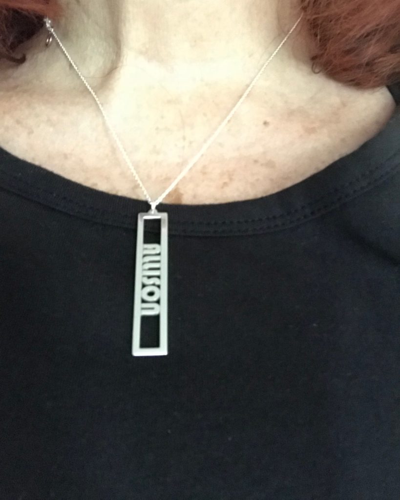 me wearing my sterling silver name necklace from Messages In Metal against a black top, neversaydiebeauty.com