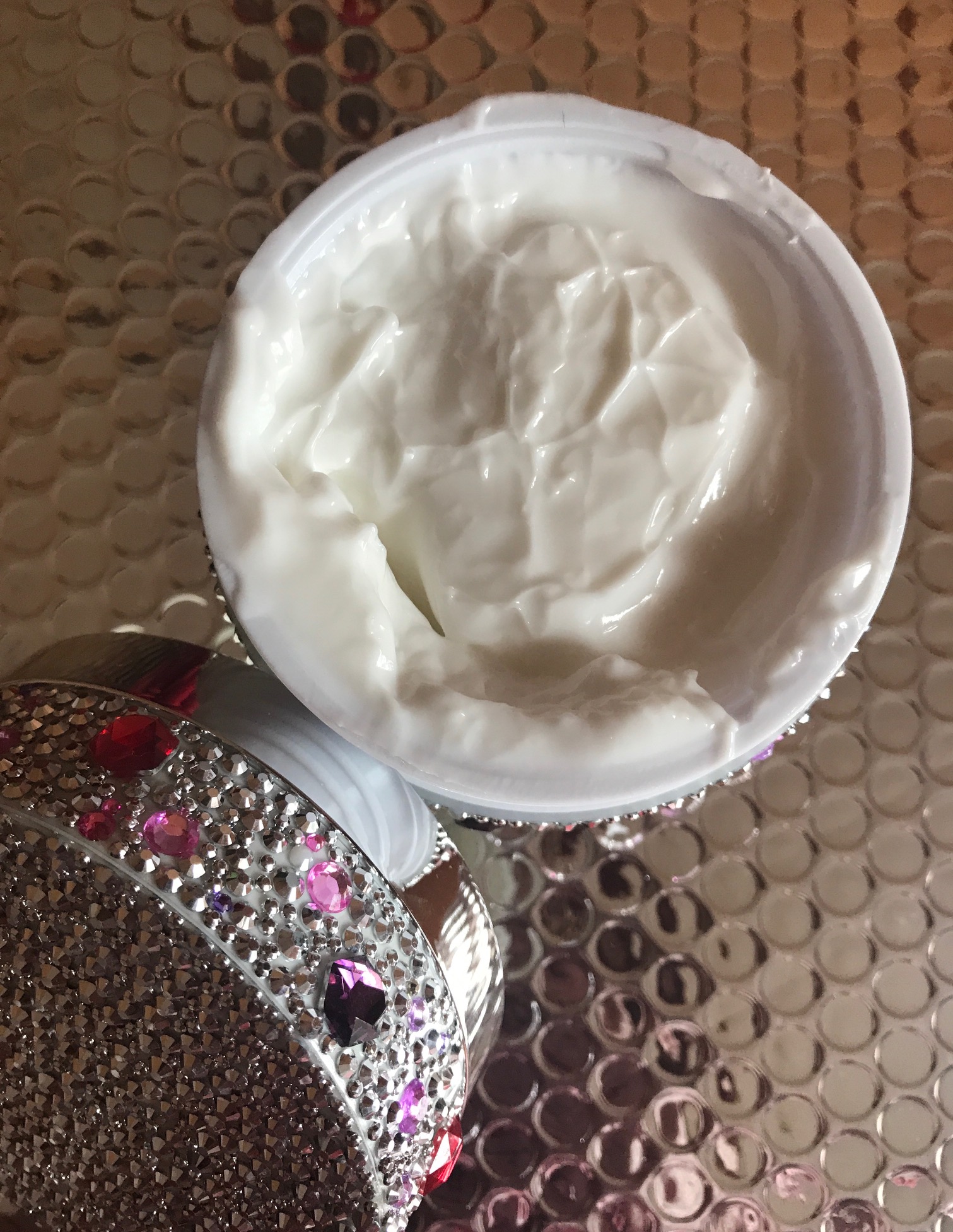 the white cream inside the jar of PRAI Throat & Decolletage Cream, neversaydiebeauty.com