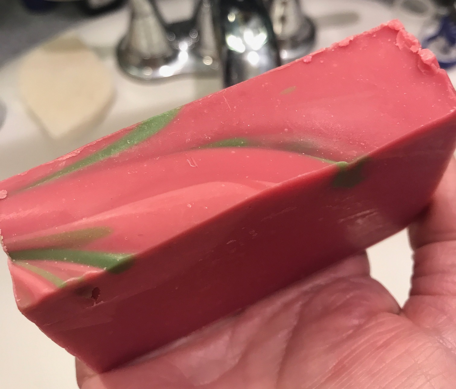 pink handcrafted bar soap with green accents from Village Naturals Aromatherapy Hydrate & Exfoliate Soap, neversaydiebeauty.com