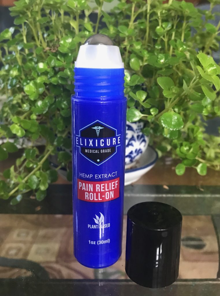 open bottle showing the metal rollerball atop the Elixicure Pain Relief Roll-On, neversaydiebeauty.com