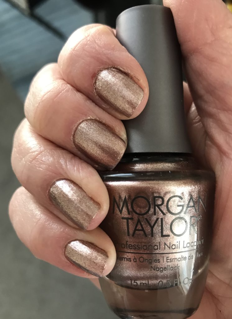finger swatch with bottle of Morgan Taylor Nail Lacquer, shade No Way Rose a metallic rose gold, neversaydiebeauty.com