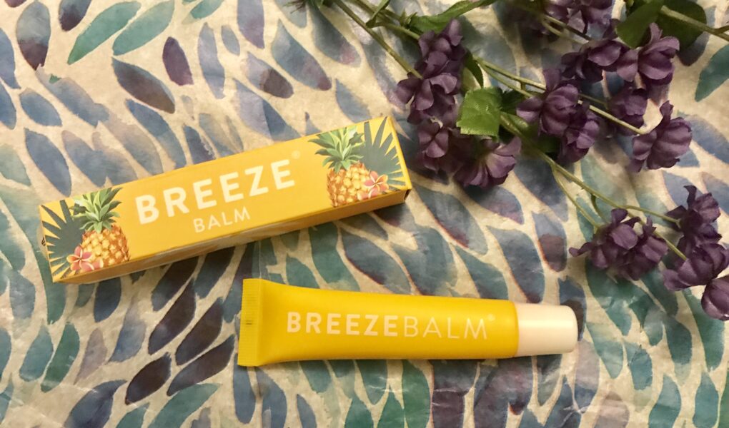 yellow box and tube of BreezeBalm Lip Balm Pineapple Pash scent, neversaydiebeauty.com