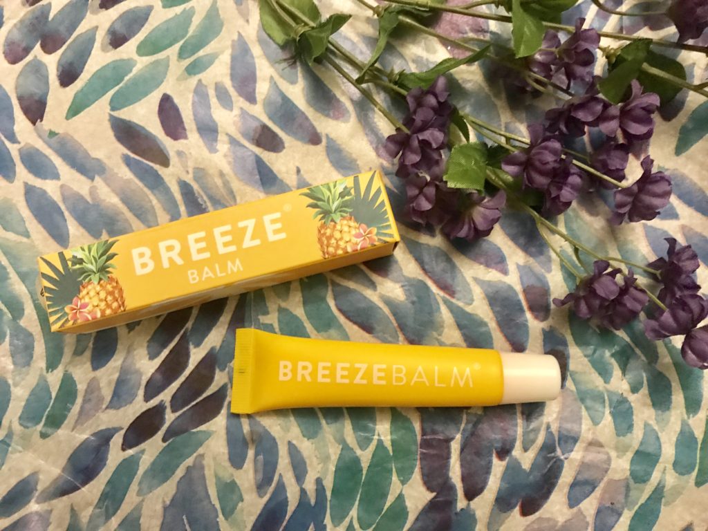 yellow box and tube of BreezeBalm Lip Balm Pineapple Pash scent, neversaydiebeauty.com