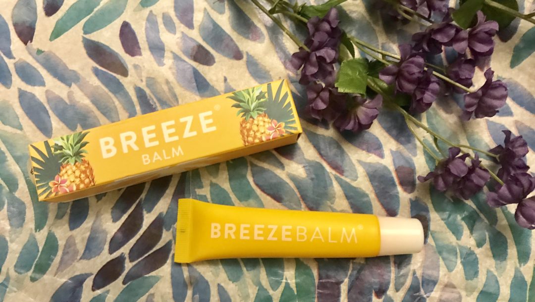 yellow box and tube of BreezeBalm Lip Balm Pineapple Pash scent, neversaydiebeauty.com