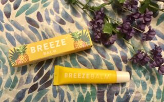 yellow box and tube of BreezeBalm Lip Balm Pineapple Pash scent, neversaydiebeauty.com