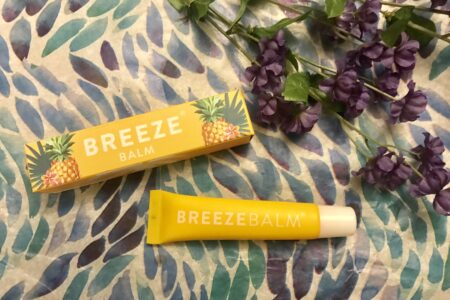 yellow box and tube of BreezeBalm Lip Balm Pineapple Pash scent, neversaydiebeauty.com