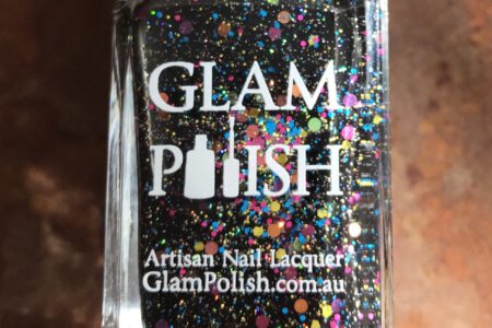 closeup of the bottle of Glam Polish "We Will Rock You 2.0", a black polish with glitter and flakes, neversaydiebeauty.com