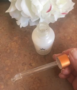 glass dropper with milky PRAI Potent-C Power Drops, a brightening serum, neversaydiebeauty.com