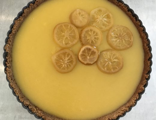 lemon tart in the tart pan with candied lemon slices on top, neversaydiebeauty.com