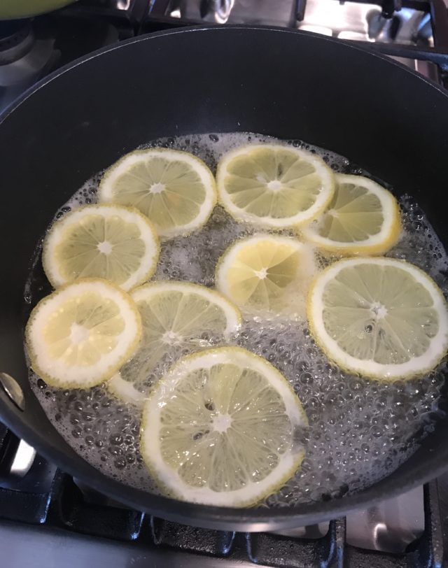 lemon slices simmering in sugar water solution in saucepan, neversaydiebeauty.com