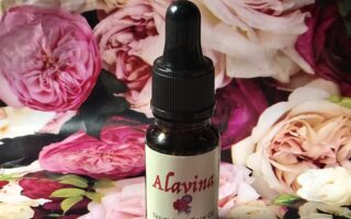 bottle of organic Alavina Nourishing Face Oil against a floral background, neversaydiebeauty.com