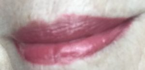 lip swatch of BECCA Glow Gloss in rosy pink Snapdragon worn over Estee Lauder Pure Color Love Lipstick in mauve shade Strapless