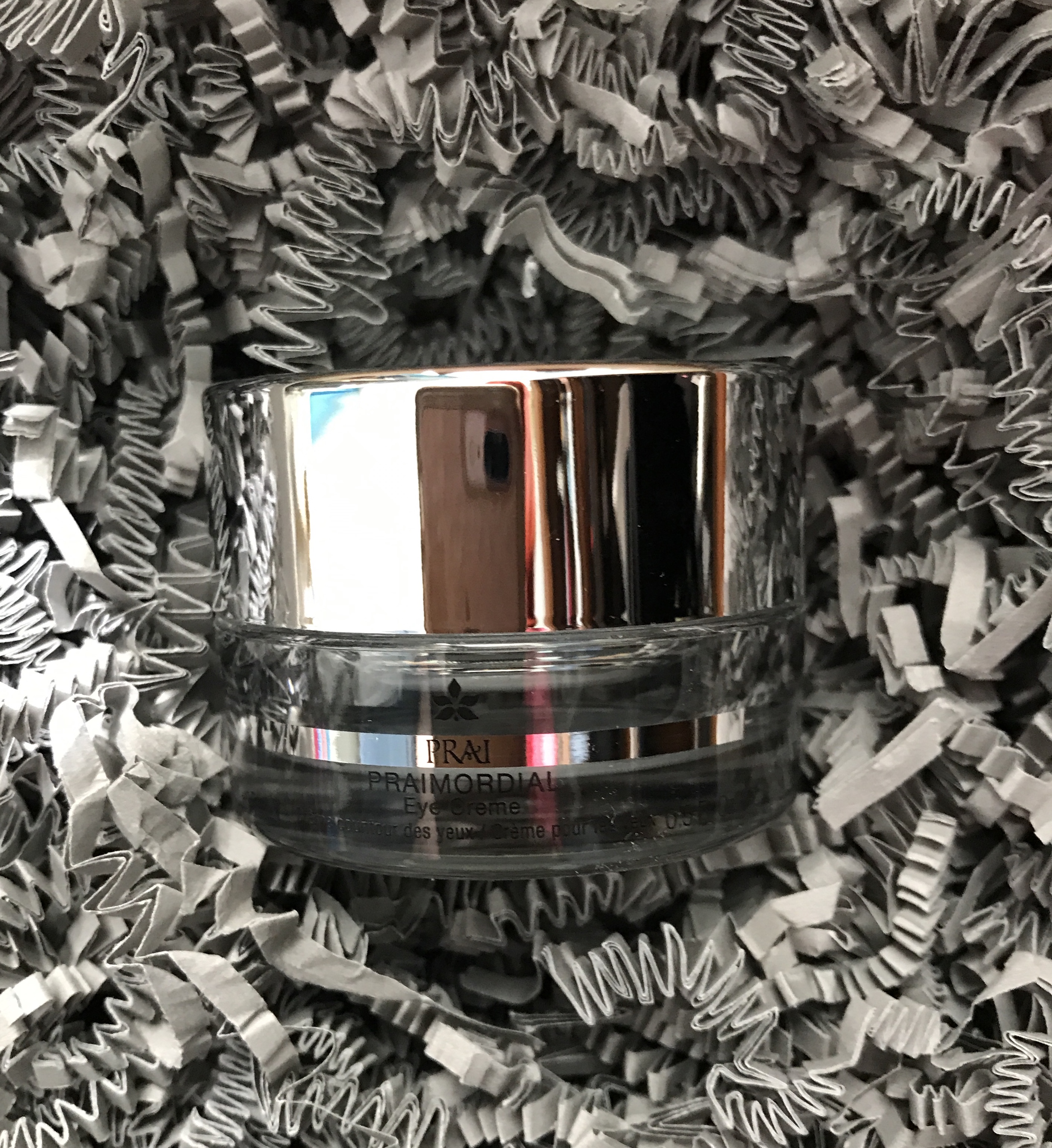 jar of PRAImordial Eye Creme against silver paper shreds, neversaydiebeauty.com