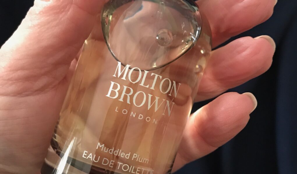 me holding the spray bottle of Molton Brown Muddled Plum eau de toilette, neversaydiebeauty.com