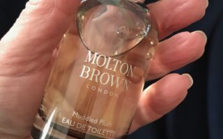 me holding the spray bottle of Molton Brown Muddled Plum eau de toilette, neversaydiebeauty.com