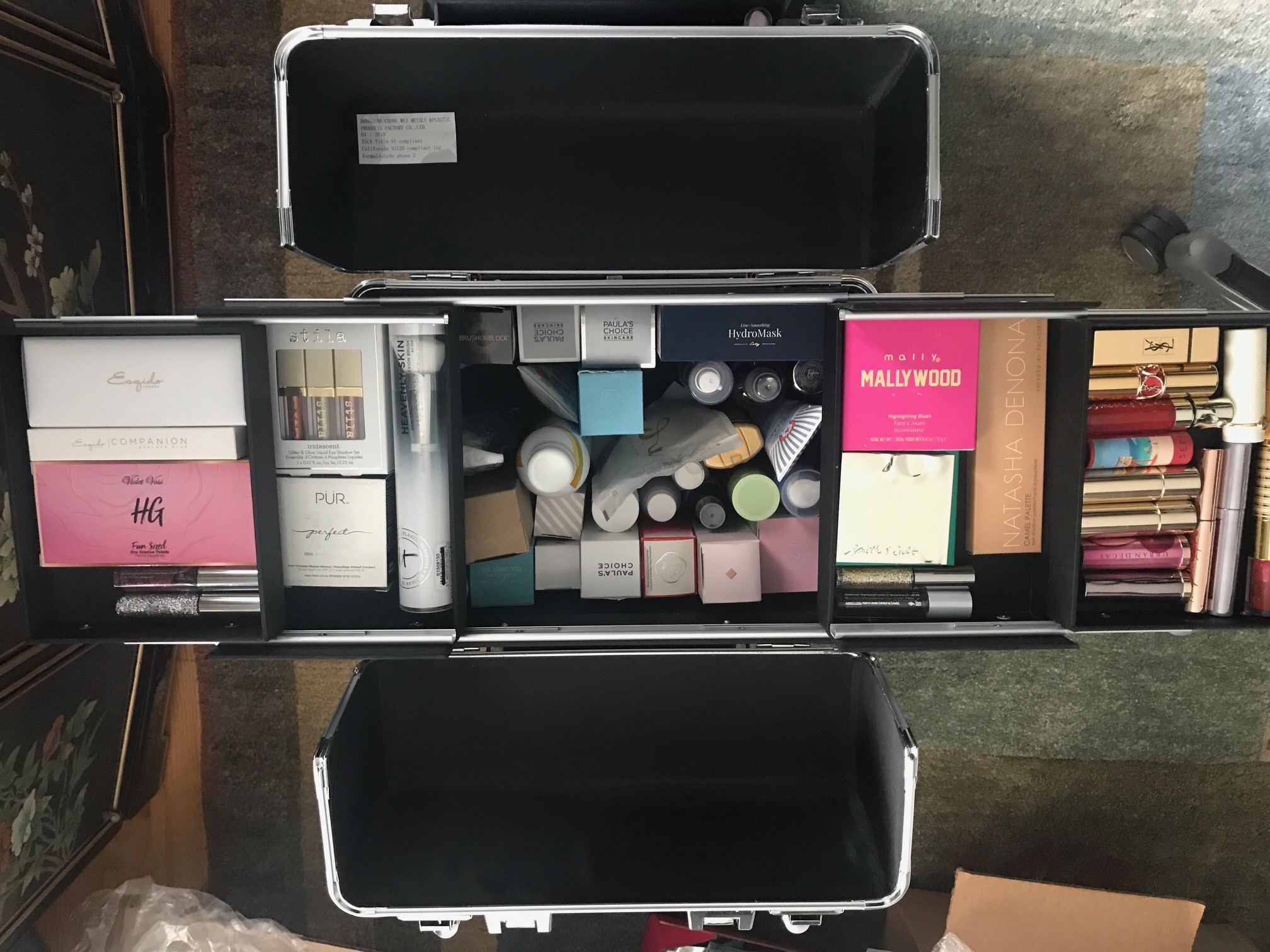 top down view of the Yaheetech train case makeup trolley with the upper drawers and deep well filled with cosmetics, neversaydiebeauty.com