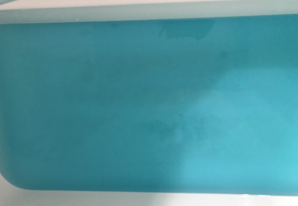 bright turquoise bathwater from HALLU Mermaid Splash Bath Bomb