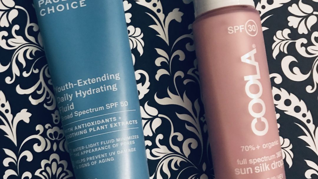 tube of Paula's Choice Youth Extending Hydrating Fluid SPF 50 and bottle of Coola Sun Silk Drops SPF 30