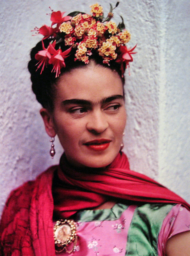 color photo of Frida Kahlo with flowers in her hair by Nickolas Muray