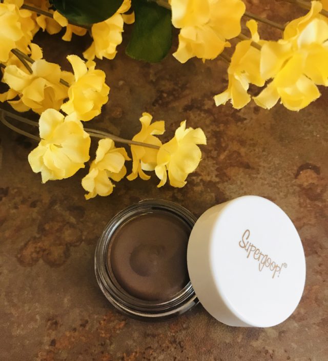 pot of Supergoop Shimmershade Eyeshadow open to show Sunset, a deep brown cream shadow