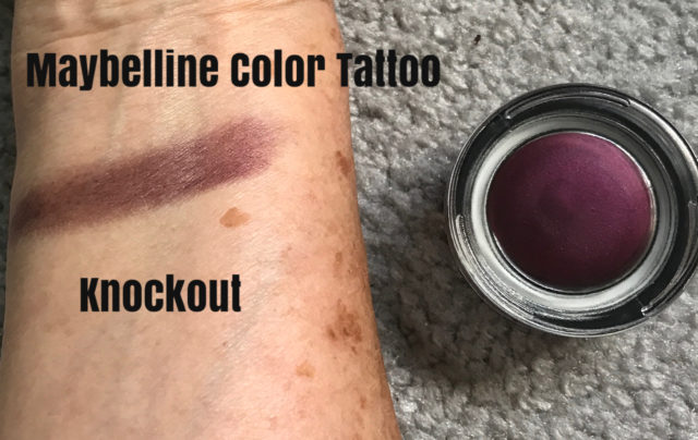 swatch on my arm of Maybelline Color Tattoo, a deep grape shade called Knockout and the glass pot it comes in