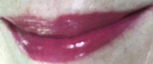 lip swatch of Berry Blessed shade of Revlon Ultra HD Vinyl Lip Polish in indirect light
