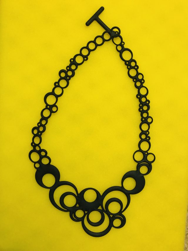 Batacuda "Night Bubbles" black necklace against yellow background