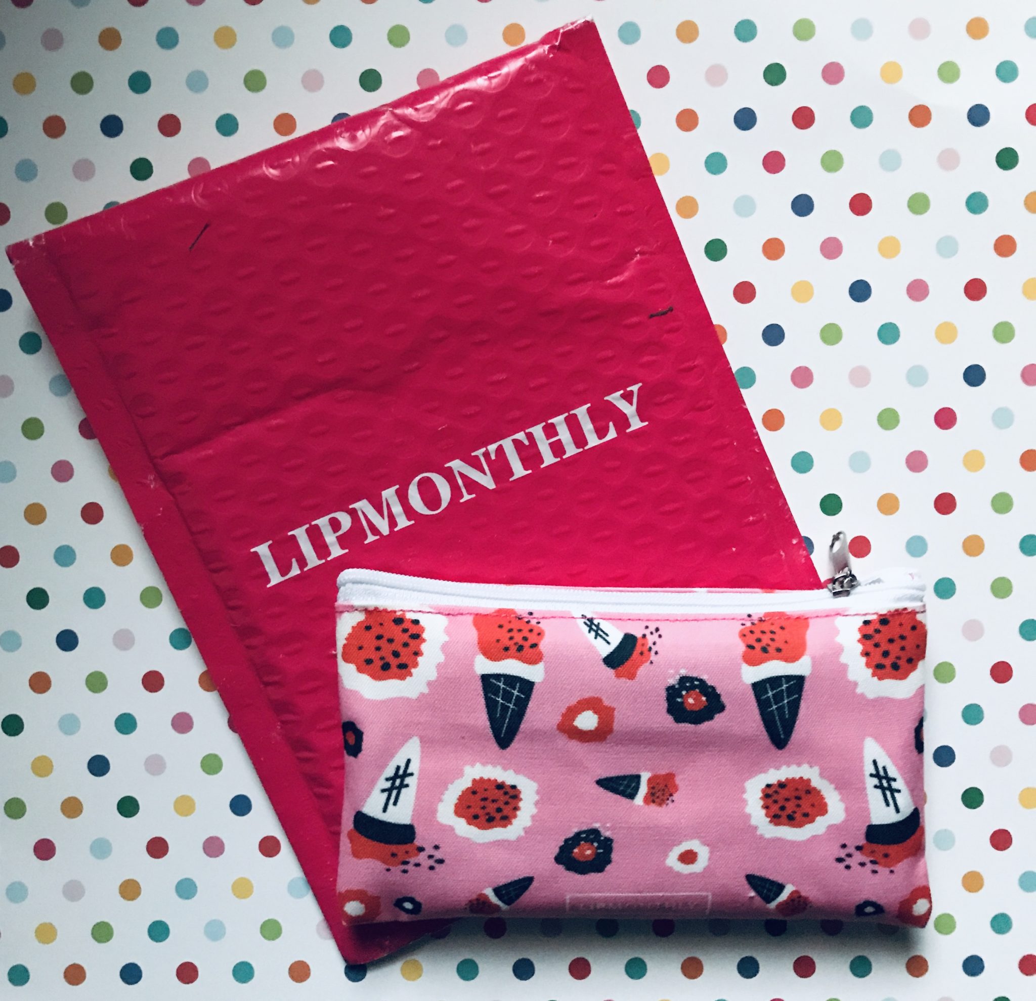 bright pink Lip Monthly mailer and pink pattern makeup bag for December 2019