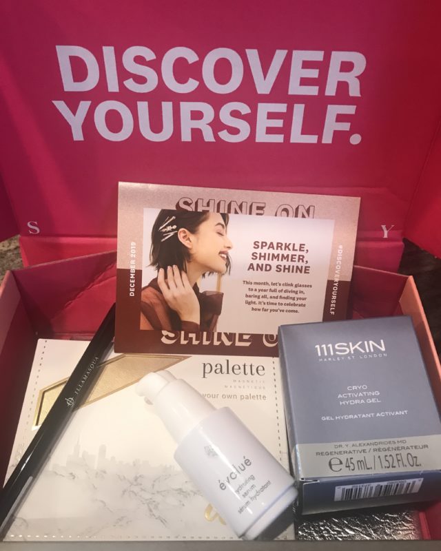 inside the shipping box for Ipsy Glam Bag Plus "Shine On" for December 2019 showing some of the beauty products inside