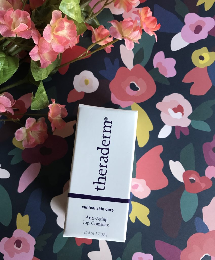 the box that Theraderm Anti-Aging Lip Complex comes in against a flowered background