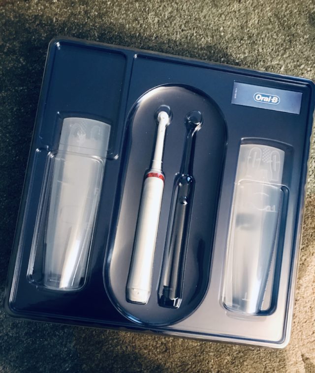 inside the Oral B Advanced Clean Electric Toothbrush box showing one handle & brush and 2 travel cases