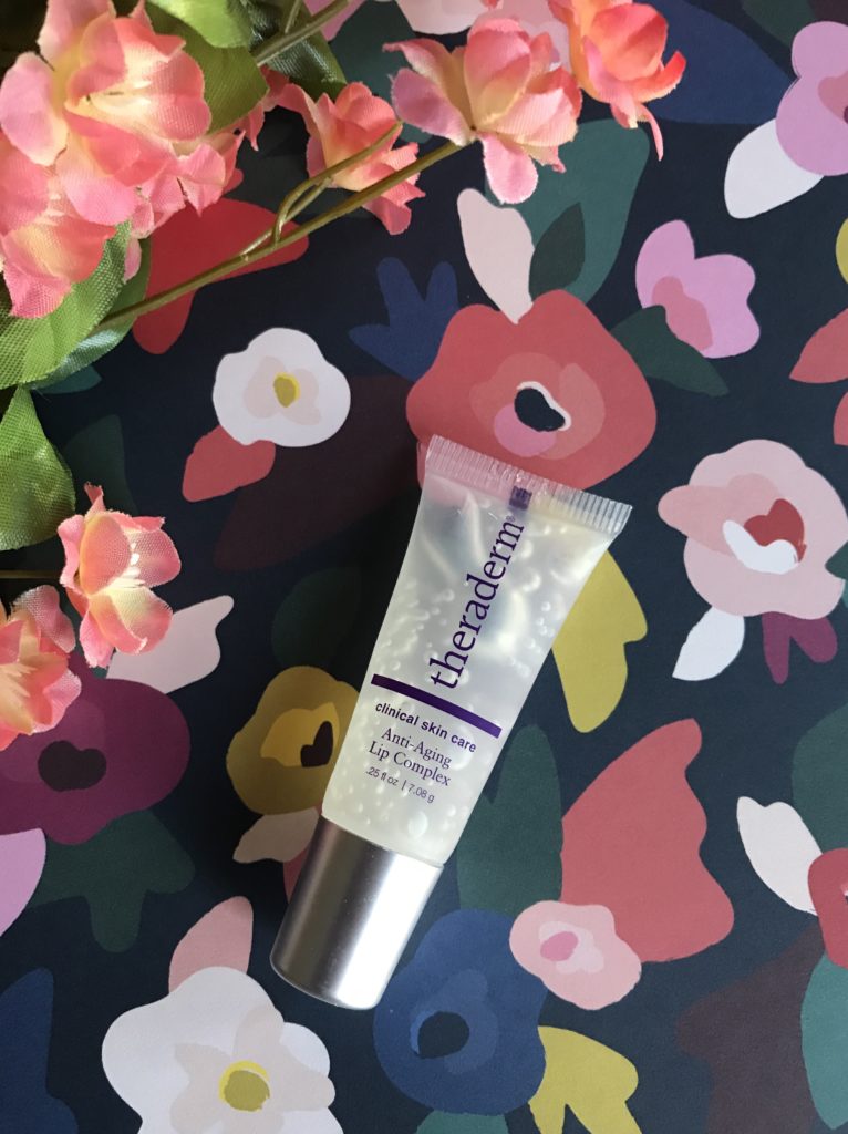 tube of Theraderm Anti-Aging Lip Complex against a flowered background