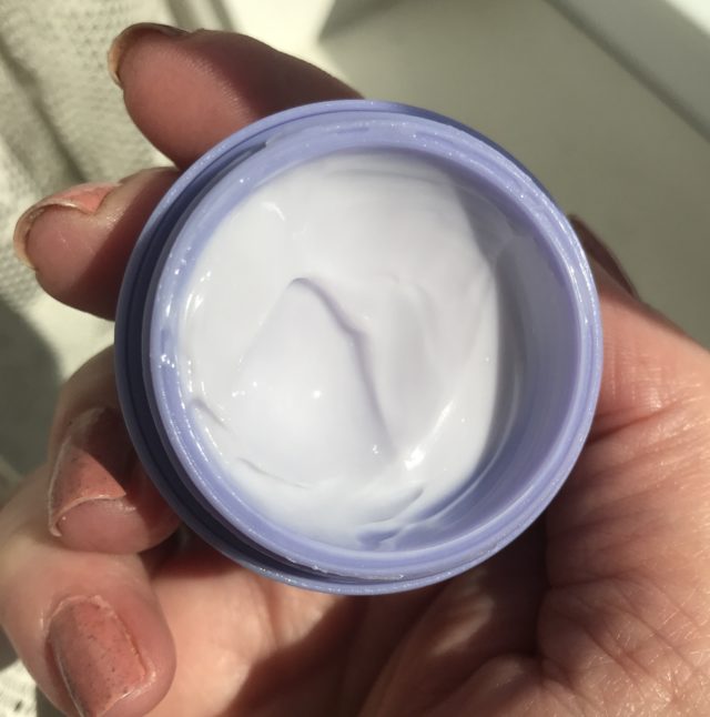 mini jar of Tatcha The Dewy Skin Moisturizer open to show the pale lavender cream inside